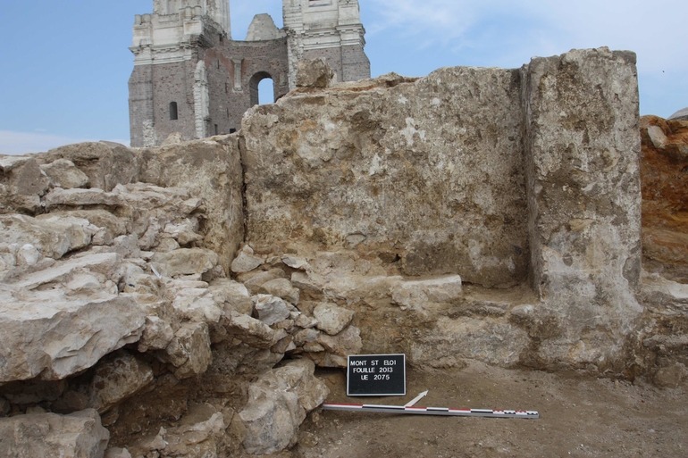 Vue des enduits ocres, décorés de motifs en faux-appareil blancs, imitant les lignes d'une maçonnerie