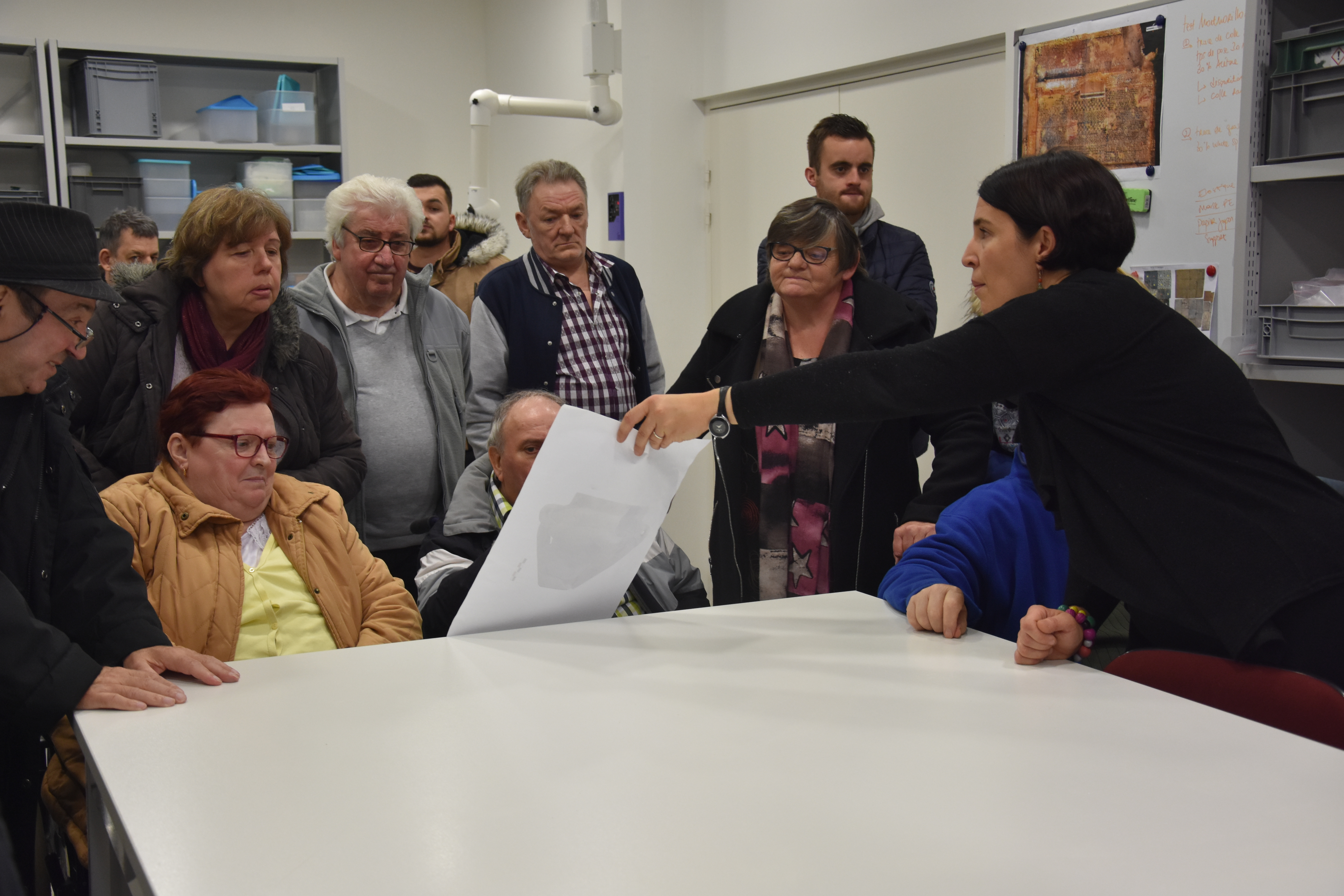 Des résidents d'EHPAD découvre l'archéologie avec la responsable de la médiation à la Maison de l'Archéologie.