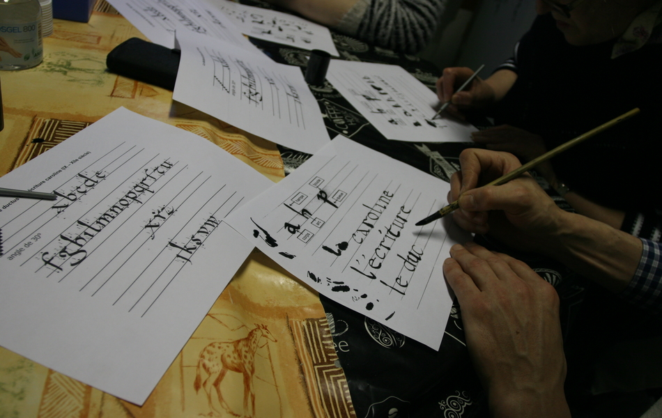 Photo de plusieurs patients réalisant des calligraphies lors un atelier.