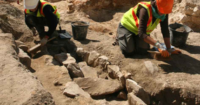 Des archéologues dégagent une tombe à coffrage en dalles de grès. L'architecture funéraire caractérise souvent des pratiques propres à chaque époque.