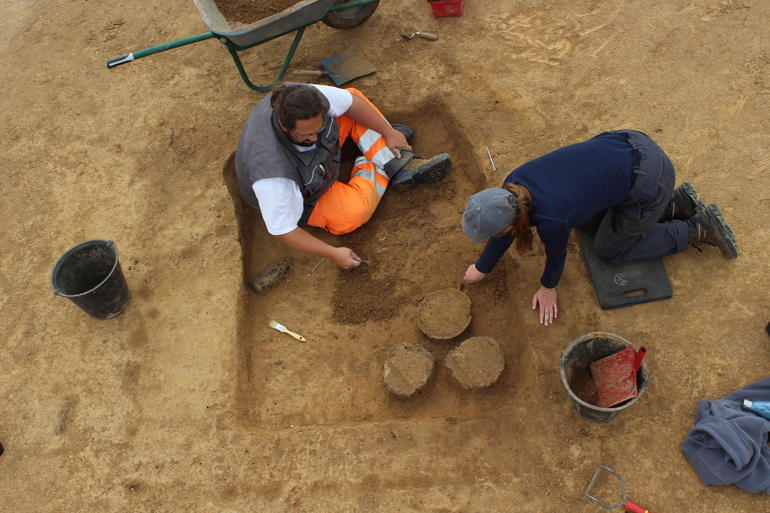 Deux archélogues fouillent une sépulture