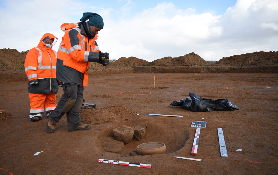 Des archéologues prennent une photo d'une tombe à créamtion