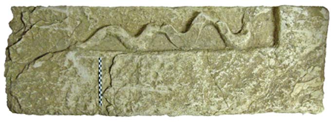 bloc orné d’un serpent sculpté en bas-relief