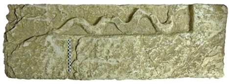 bloc orné d’un serpent sculpté en bas-relief