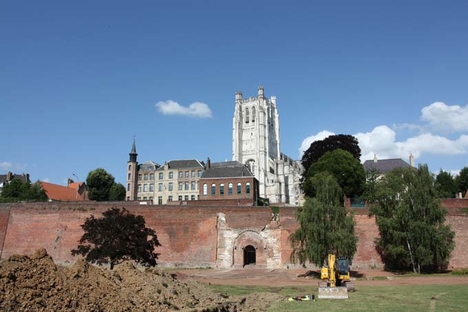 vue des remparts et des tranchées de sondages, avec en arrière plan, la tour de la cathédrale Notre-Dame.